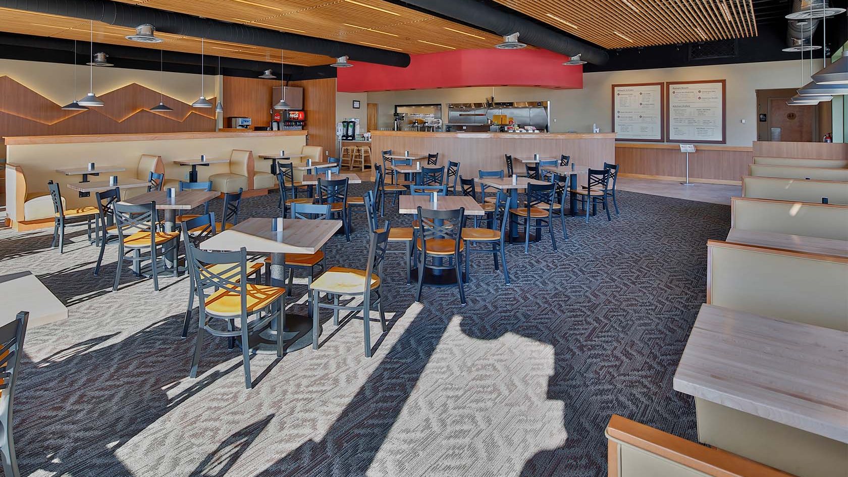 The dining room at Little Ari's Japanese Kitchen with wood slat ceiling, booths and the open kitchen